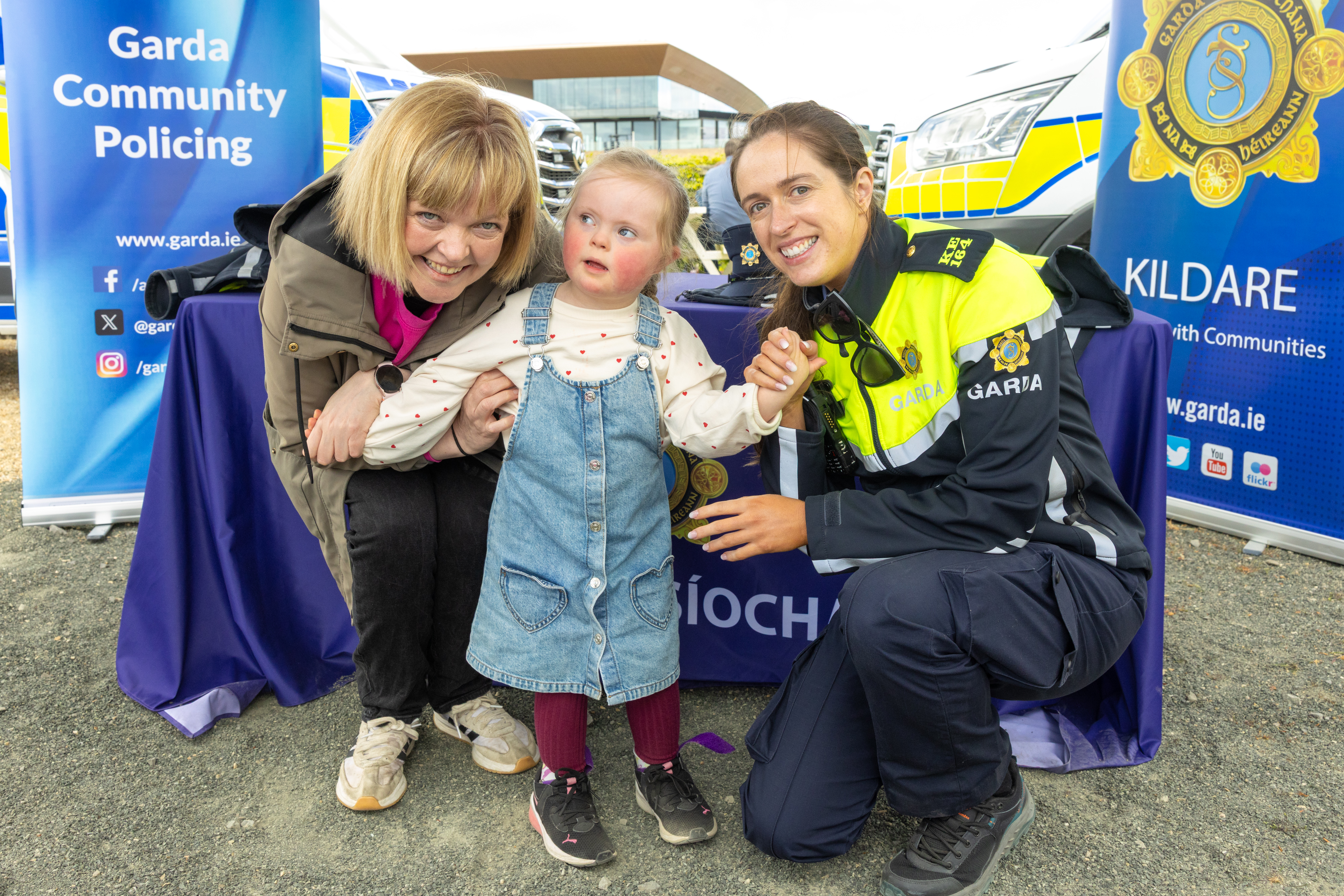 People at a Garda stall with a Garda. 